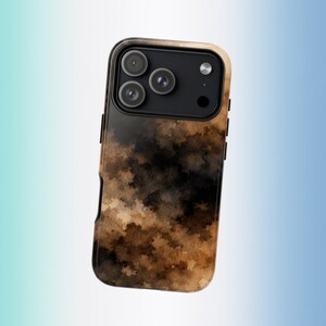 May include: A smartphone case featuring a dark, abstract watercolor pattern in shades of black, brown, and tan. The case has a rectangular cutout at the top for a triple-lens camera system and a flash, with a black frame surrounding the lenses.