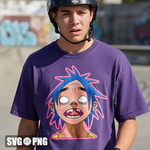 May include: A purple t-shirt featuring a cartoon graphic of a character with blue spiky hair, white eyes, and an open mouth. The character is outlined in pink. The shirt is being worn by a person wearing a black helmet.
