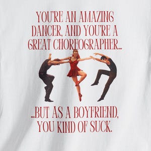 Könnte beinhalten: Weißes T-Shirt mit roter Grafik. Die Grafik zeigt eine Tänzerin in einem roten Kleid mit zwei Tänzern in schwarzen Silhouetten auf beiden Seiten. Der Text lautet: "YOU'RE AN AMAZING DANCER, AND YOU'RE A GREAT CHOREOGRAPHER... BUT AS A BOYFRIEND, YOU KIND OF SUCK."