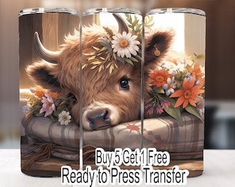 May include: A sublimation design featuring a Highland cow with a flower crown, resting on a plaid blanket. The design includes the text "Buy 5 Get 1 Free Ready to Press Transfer".