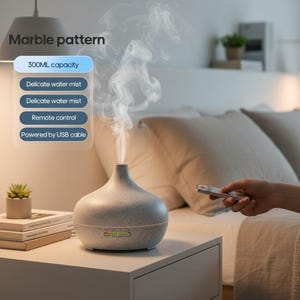 Puede incluir: Un difusor de aceites esenciales con patrón de mármol y capacidad de 300 ml, que emite una delicada bruma de agua. El dispositivo incluye un mando a distancia, funciona con cable USB y presenta etiquetas de texto con sus características.