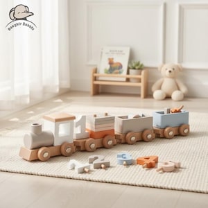 Peut inclure: Un train jouet en bois avec une locomotive gris clair, une cabine blanche et trois wagons colorés. Les wagons sont dans des tons orange, gris et bleu. Comprend des blocs de chiffres en bois. Le train est sur un tapis crème.