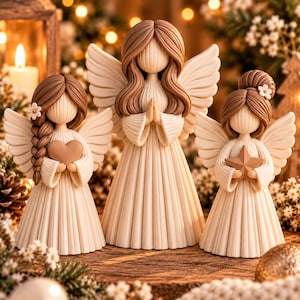 May include: Three faceless angel figurines with brown hair and cream-coloured pleated gowns. The left angel holds a heart, the centre angel has hands in prayer, and the right angel holds a star. Each angel features large, textured wings.