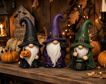Könnte beinhalten: Drei Halloween-Gnome mit spitzen Hüten und Gürteln. Der schwarze Gnom hält einen Kürbis, der violette Gnom eine schwarze Katze und der grüne Gnom rührt in einem schwarzen Kessel mit Pentagramm-Symbol. Jeder hat einen langen weißen Bart.
