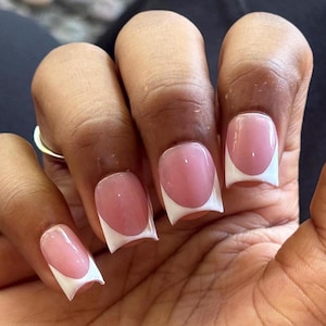 May include: A set of square-shaped artificial nails featuring a classic French manicure design. Each nail has a translucent pink base color with a crisp, solid white tip. The nails are shaped with sharp, defined corners and a smooth, glossy finish.