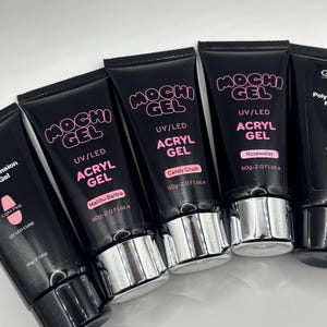 Peut inclure: Une collection de tubes noirs de Mochi Gel UV/LED Acryl Gel, contenant chacun 60g ou 2,0 fl. oz. Les tubes portent des noms de couleurs spécifiques, notamment Light Pink, Malibu Barbie, Candy Crush et Rosewater, avec des bouchons argentés.