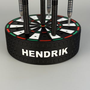 Könnte beinhalten: Ein Set aus drei Keramikbechern mit gesprenkelter, matter Oberfläche. Die Becher sind in Creme-, Hellgrau- und Dunkelgrautönen gehalten. Jeder Becher hat ein schlichtes, modernes Design und einen abgerundeten Henkel.