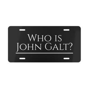 Op de afbeelding: Zwart kenteken met de witte tekst "WHO IS JOHN GALT?". De tekst is gecentreerd en onderstreept. De plaat heeft vier montagegaten, één in elke hoek.