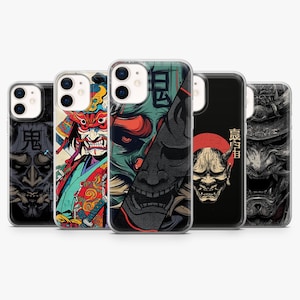 May include: A collection of phone cases featuring Japanese demon mask designs. The cases display various color schemes, including red, black, and teal, with intricate details and bold graphics. The cases are designed to fit a smartphone.