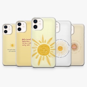 Pode incluir: Uma coleção de capas de telemóvel com designs amarelos e brancos. As capas apresentam gráficos de sol e citações inspiradoras como "Sinta o sol de dentro para fora" e "O otimismo delirante é a única saída".