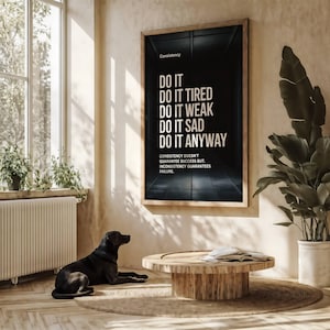 May include: A framed motivational poster with the text "DO IT" followed by "DO IT TIRED, WEAK, SAD, ANYWAY." The poster is in a room with a window, plants, and a wooden coffee table. A black dog is lying on the floor.
