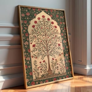 Puede incluir: Una impresión artística enmarcada que presenta un árbol estilizado con flores rojas y hojas verdes. La obra de arte tiene un fondo crema, un borde floral verde y un marco dorado. La impresión se apoya en una pared blanca sobre un suelo de madera.