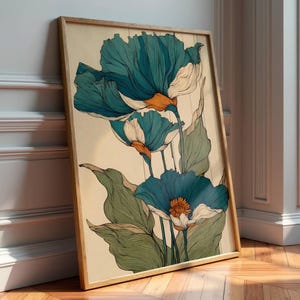 Puede incluir: Una impresión artística enmarcada con flores azules y blancas estilizadas con centros naranjas y hojas verdes. La obra de arte tiene una estética vintage, con un fondo beige claro y un marco de madera natural. La impresión está apoyada contra una pared blanca.