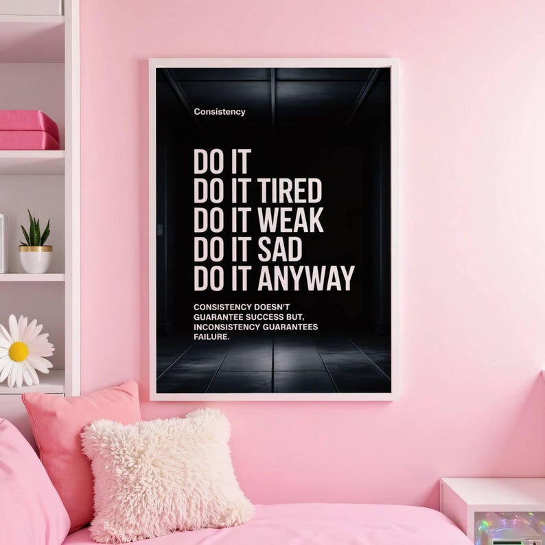 May include: A framed motivational poster with the word "Consistency" at the top. The poster features the text "DO IT, DO IT TIRED, DO IT WEAK, DO IT SAD, DO IT ANYWAY" in white font against a dark background. The bottom text reads "Consistency doesn't guarantee success but, inconsistency guarantees failure."