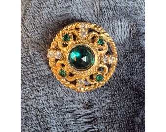 Broche redondo vintage en tono dorado con diamantes de imitación transparentes de color verde esmeralda, estilo victoriano.