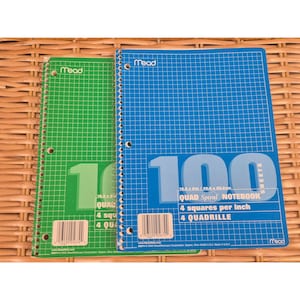 May include: Two Mead quad spiral notebooks, one green and one blue, each featuring a grid pattern, 100 sheets, and 4 squares per inch. The covers display the text Mead, 100 Sheets, Quad Spiral Notebook, 4 squares per inch, and 4 quadrille.