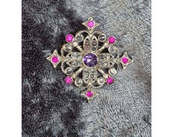 Broche vintage con cruz de Malta, diamantes de imitación morados y rosas, y alfiler de tono plateado envejecido.