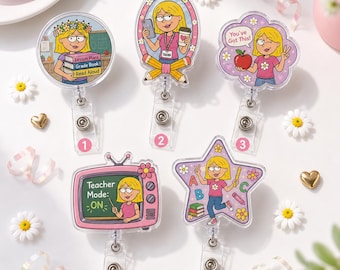 May include: Five acrylic badge reels featuring cartoon teacher illustrations. Designs include a teacher with books, a teacher with a phone and coffee, a teacher with an apple and text "You've Got This!", a TV screen with "Teacher Mode: ON", and a star shape.