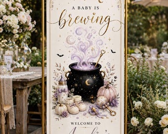May include: A vertical rectangular banner in a gold metal frame with lavender bows, featuring the text A BABY IS BREWING, a black cauldron with purple smoke, baby bottles, booties, a rattle, and pumpkins, ending with WELCOME TO Amelia's BABY SHOWER.