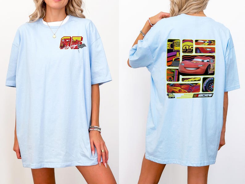 May include: Light blue t-shirt featuring a graphic of a red race car with the number 95 and the word "HACHOW". The front of the shirt has a smaller graphic with the number 95 and a checkered flag. The shirt has short sleeves and a relaxed fit.