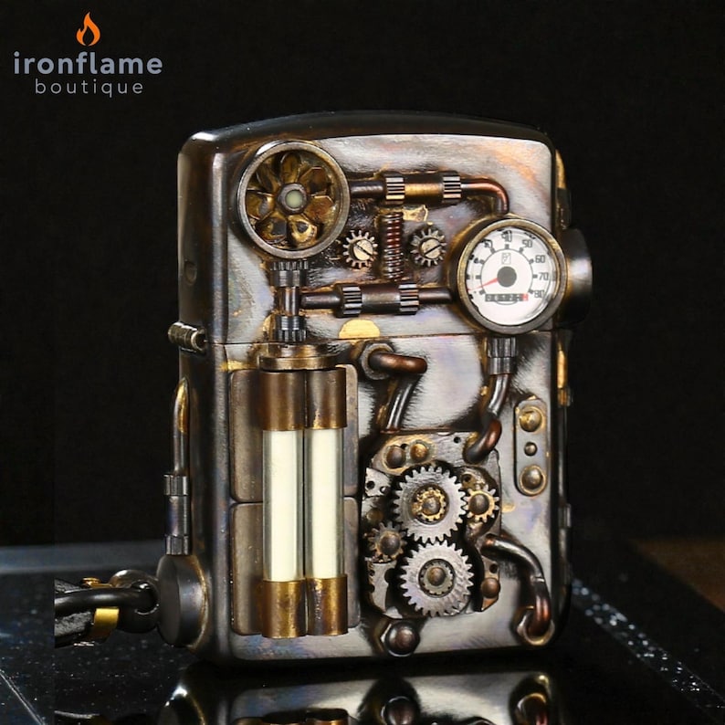 Peut inclure: Un briquet de style steampunk avec des engrenages complexes, des jauges et des accents m&eacute;talliques. Le briquet pr&eacute;sente une combinaison de tons bronze, argent et or, avec une petite jauge et un &eacute;l&eacute;ment en forme d'&eacute;ventail. La marque "ironflame boutique" est visible.