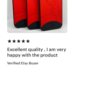 May include: Red phone cases with black trim. The cases have a curved design and feature the Coca-Cola logo in a cursive font. The cases are shown in a group of three, with the design visible.