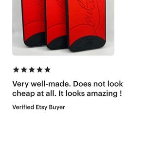 May include: Red phone cases with black trim. The cases have a curved design and a logo on the back. The cases are shown in a group of three. The cases are for a phone.