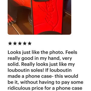 May include: Red phone case with a black border. The case features a textured design and a logo. The phone case is shown with a black shoe with red soles.