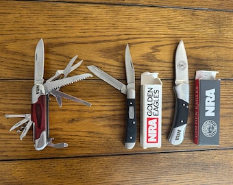 Three vintage NRA pocketknives, two with boxes, near mint or close
