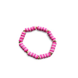 Puede incluir: Una pulsera de cuentas rosas y blancas con cuentas espaciadoras doradas. La pulsera presenta cuentas planas en forma de disco en tonos rosas y blancos alternos. Las cuentas están ensartadas con pequeñas cuentas doradas que separan las secciones.