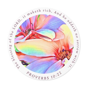 Puede incluir: Una pegatina redonda con un diseño floral colorido en tonos rosa, morado y amarillo. La pegatina incluye el texto "La bendición del SEÑOR enriquece, y no añade tristeza con ella. PROVERBIOS 10:22" dispuesto en un patrón circular.
