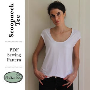 May include: A white scoopneck tee shirt sewing pattern. The pattern is available as a PDF download. The text "Scoopneck Tee" and "PDF Sewing Pattern" is printed on the image. The image also includes the text "Atelier Joy".