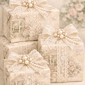 Könnte beinhalten: Vier Geschenkboxen, verpackt in cremefarbenem Papier mit Blumen- und Pavillondesign. Jede Box ist mit einer cremefarbenen Spitzenschleife und Perlen verziert. Die Boxen sind gestapelt und erzeugen eine romantische und elegante Präsentation.