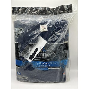 以下が含まれることがあります： 透明なビニール袋に密封された、濃いネイビーブルーのスポーツシャツのパッケージ。パッケージには「MEN'S ATHLETIC SHIRTS」や「100% COTTON PRESHRUNK」などの文字が記載されています。「LARGE」と書かれたラベルも付いています。「FRUIT OF THE LOOM」のブランド名も確認できます。
