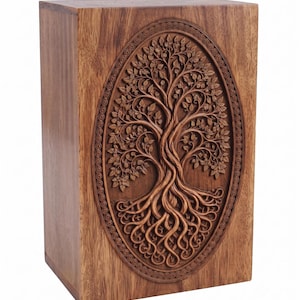 A wooden urn box featuring an oval carving of a detailed tree of life with sprawling roots and branches.