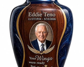 May include: A decorative cremation urn featuring a polished blue marbleized finish and a central wood-grain panel. The urn displays a portrait of a person, the name Eddie Teno, dates 11/17/1934 - 5/15/2026, and the text Your Wings were ready But my Heart was not.