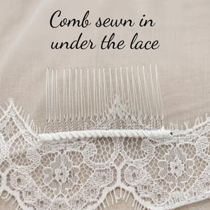 Puede incluir: Una peineta de metal plateado con dientes finos y rectos sobre una base de tela blanca. La peineta est&aacute; cosida debajo de un trozo de encaje blanco con motivos florales. El texto "Comb sewn in under the lace" aparece impreso en negro.