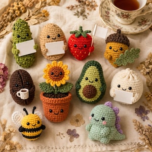 May include: A collection of ten small crocheted figures including a green pickle, a tan potato, a red strawberry with a flag, an acorn, a brown coffee bean, a sunflower in a pot, an avocado, a white dumpling, a bee, and a green dinosaur.