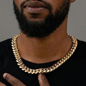 Gold Miami Cuban link chain worn at the collarbone.