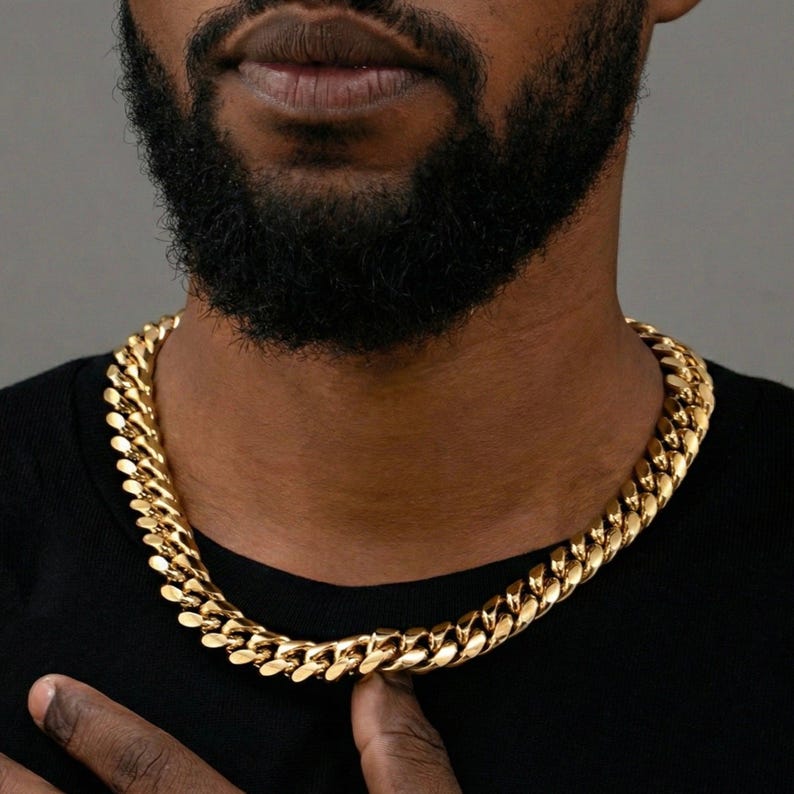 Gold Miami Cuban link chain worn at the collarbone.