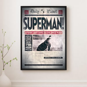 Puede incluir: Impresión enmarcada de un periódico Daily Planet vintage con el titular "SUPERMAN!". El artículo incluye el texto "MYSTERY HERO SAVES FALLING SPACE PLANE" y "LIVE YEAR 2013 13 JUNIO Metropolis." Con una imagen en blanco y negro.