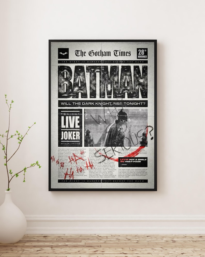 Może przedstawiać: Oprawiony czarno-biały wydruk gazety zatytułowanej "The Gotham Times" z nagł&oacute;wkiem "BATMAN". Wydruk zawiera tekst "WILL THE DARK KNIGHT RISE TONIGHT?" i "LIVE JOKER". Widoczny jest r&oacute;wnież czerwony tekst w stylu graffiti i znak zapytania.