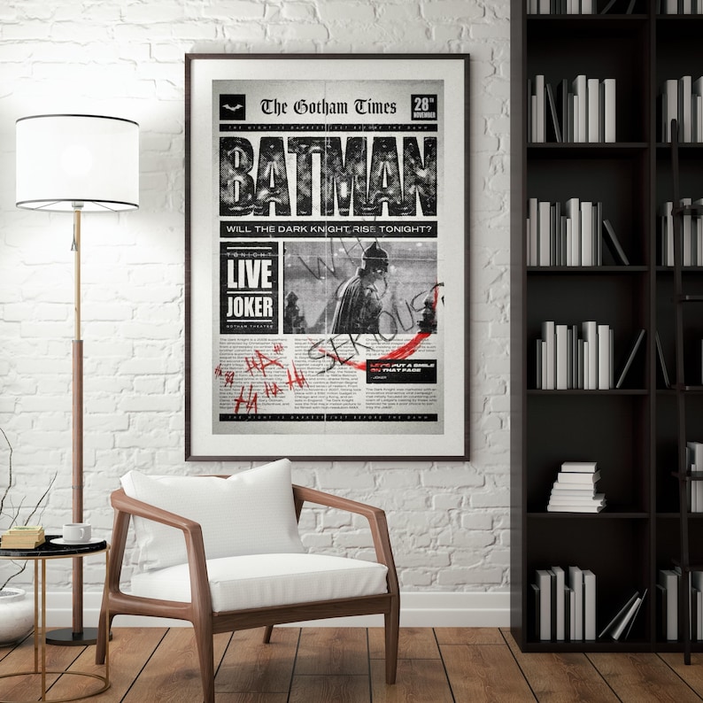 Może przedstawiać: Oprawiony czarno-biały plakat Batmana, stylizowany na stronę tytułową gazety. Nagł&oacute;wek "BATMAN" jest pogrubiony. Zawiera tekst "The Gotham Times" i "LIVE JOKER". Plakat jest w ciemnej drewnianej ramie.
