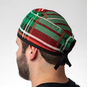 May include: A green, red, and white plaid surgical scrub cap with a black trim and ties. The cap is made of fabric and is designed to cover the head. The plaid pattern is a classic design.