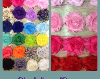 May include: A collection of fabric flower embellishments in various colors including red, pink, blue, green, yellow, orange, black, and white, with some featuring floral or polka dot patterns. The text BluebellsandBows is printed at the bottom.