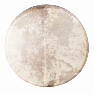 May include: A circular drumhead with a textured, off-white surface. The drumhead has a natural, aged appearance with colour variations, from light beige to darker brown. The rim of the drum is visible, showing a darker, possibly wooden, material.