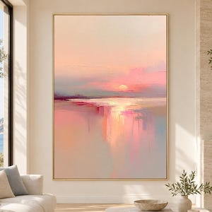 Op de afbeelding: Een groot rechthoekig schilderij op canvas met een abstract zonsonderganglandschap in zachte tinten perzik, roze en lichtblauw. Het kunstwerk toont dikke, gestructureerde penseelstreken die een gloeiende zon boven een kalme horizon weergeven.
