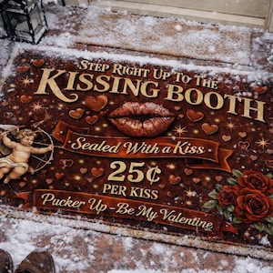 Puede incluir: Felpudo rectangular con temática de San Valentín. La alfombra presenta el texto "Step Right Up To The Kissing Booth" y "Sealed With a Kiss". También tiene una imagen de labios, corazones y un cupido.