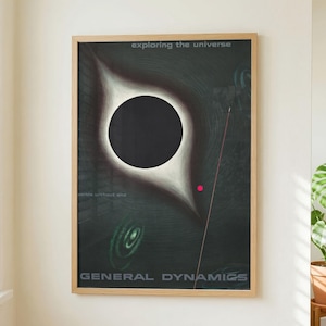 May include: A framed vertical poster featuring a dark, abstract space-themed illustration with a large black circle surrounded by a white glow. The text reads exploring the universe at the top and GENERAL DYNAMICS at the bottom in white font.