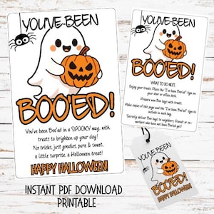 May include: A printable Halloween set featuring a white ghost holding an orange jack-o'-lantern, a black spider, and the text YOU'VE BEEN BOO'ED. The set includes a large sign, a smaller instruction card, and a gift tag with matching graphics.